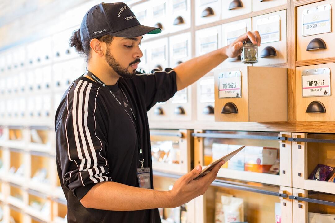 Man organizing cannabis products in dispensary drawer