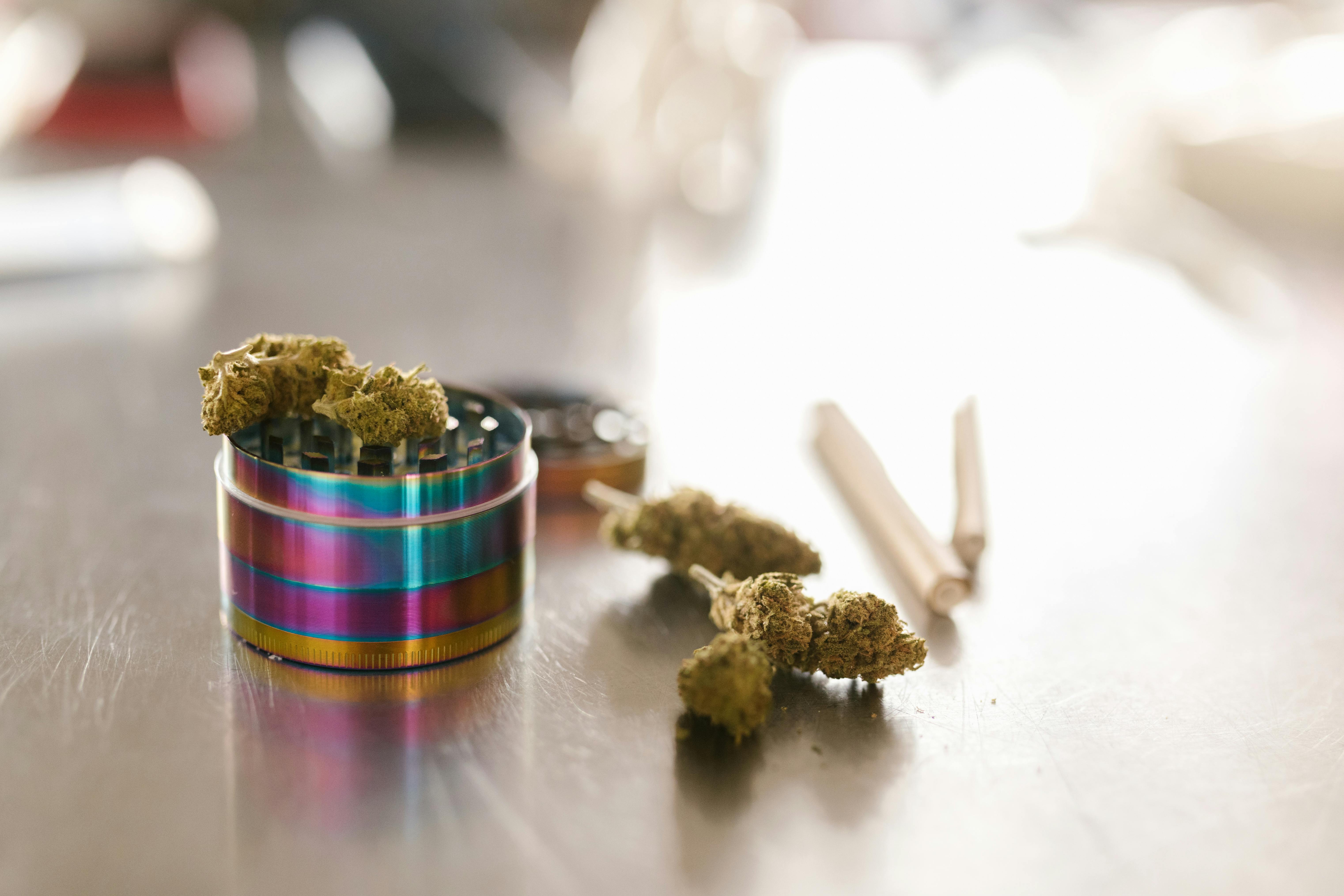 Rainbow grinder with cannabis buds and joints