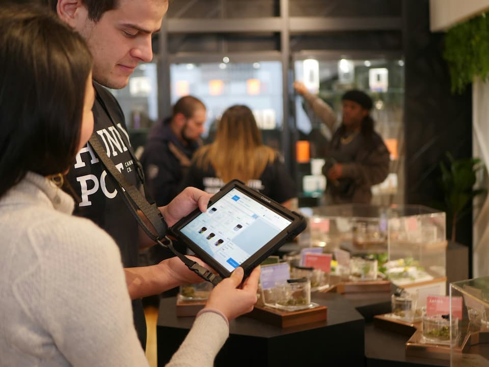 A budtender helping a customer